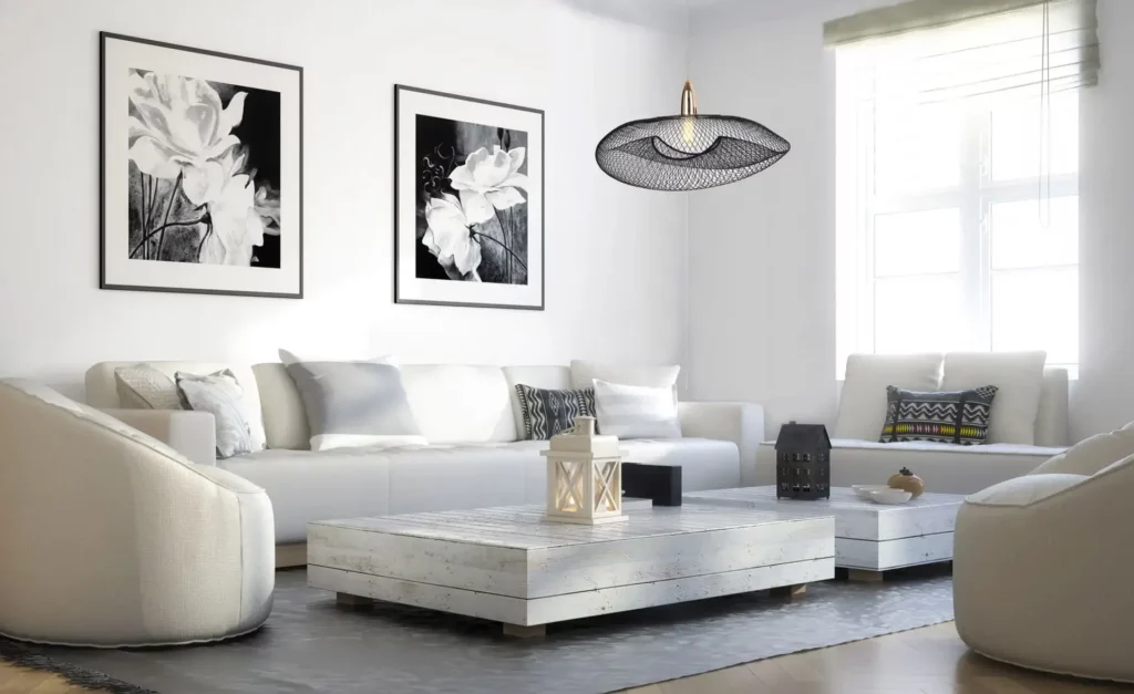a living room set up in neutral color with black and white portrait