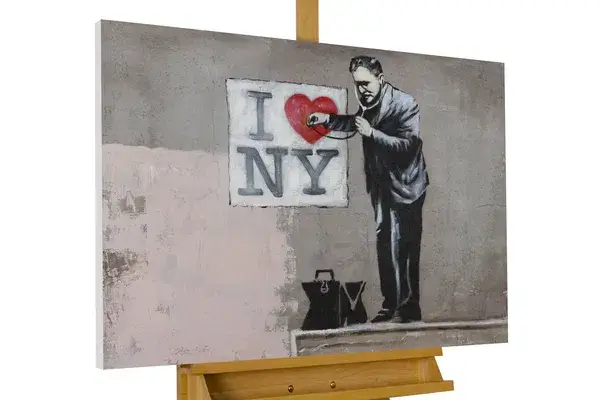 A canvas painting depicting a man with a stencil spraying red paint over the heart symbol in the phrase "I heart NY," using a black, white, and beige color palette.