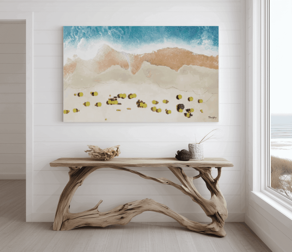 Coastal interior with white shiplap walls, driftwood console table, and beach wave painting.